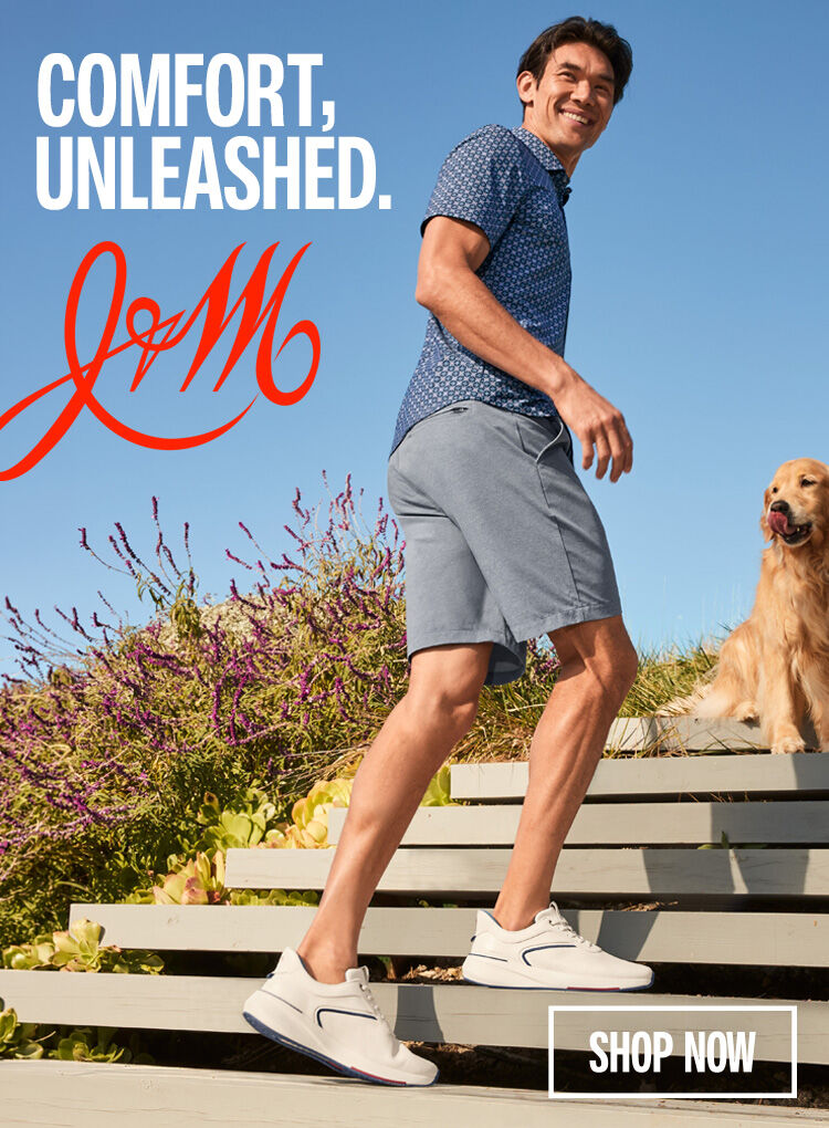 Man dressed in a Johnston & Murphy polo and shorts with athletic sneakers on leaning on steps outside. There is a Golden Retriever standing on the steps above him with a shop now button.